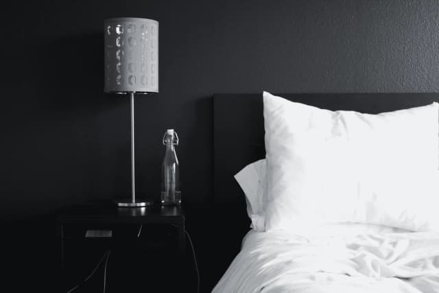 Bedside lamp and pillows in a hotel room