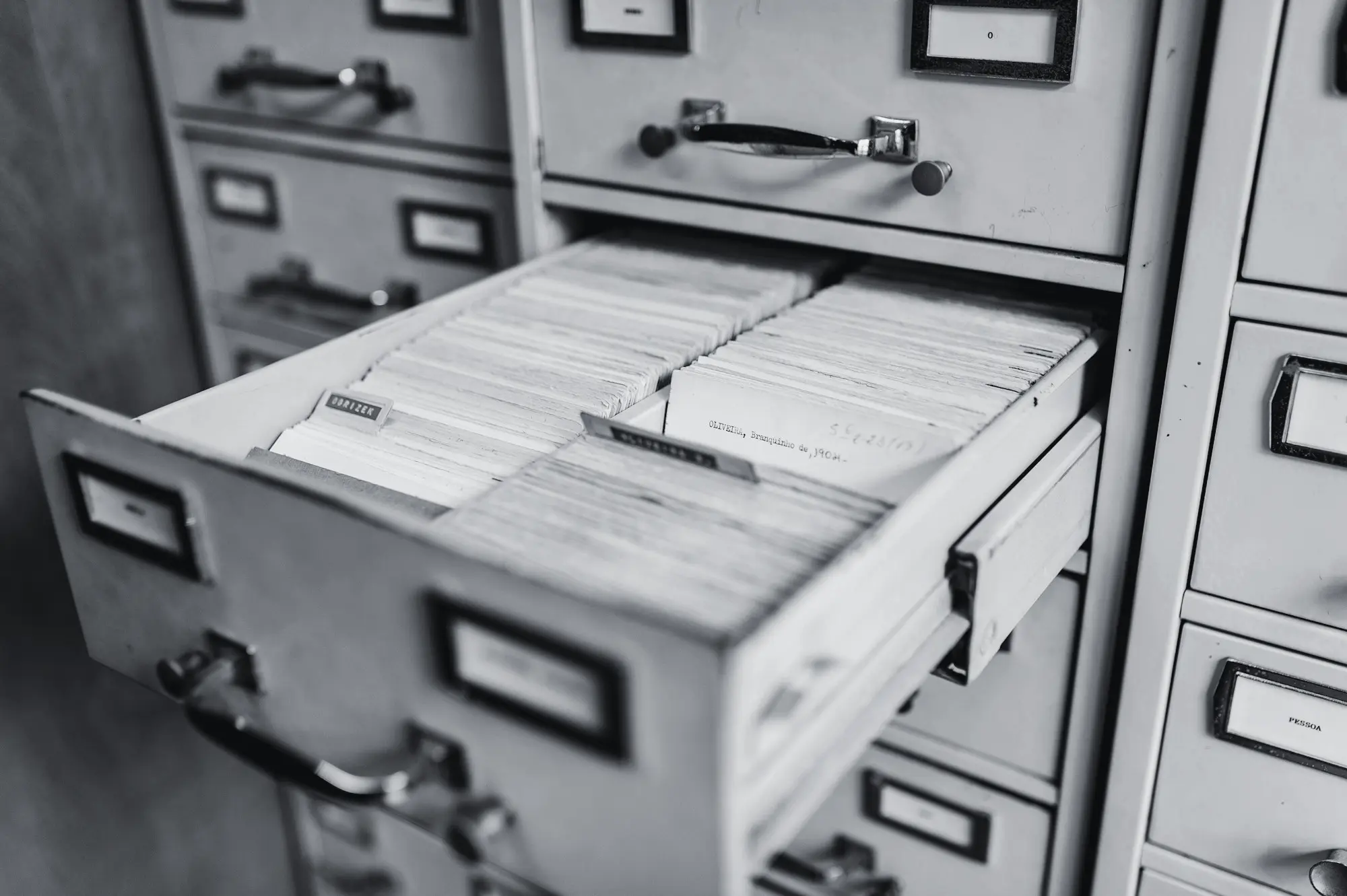 Open drawer of a card index cabinet, filled with tightly packed cards