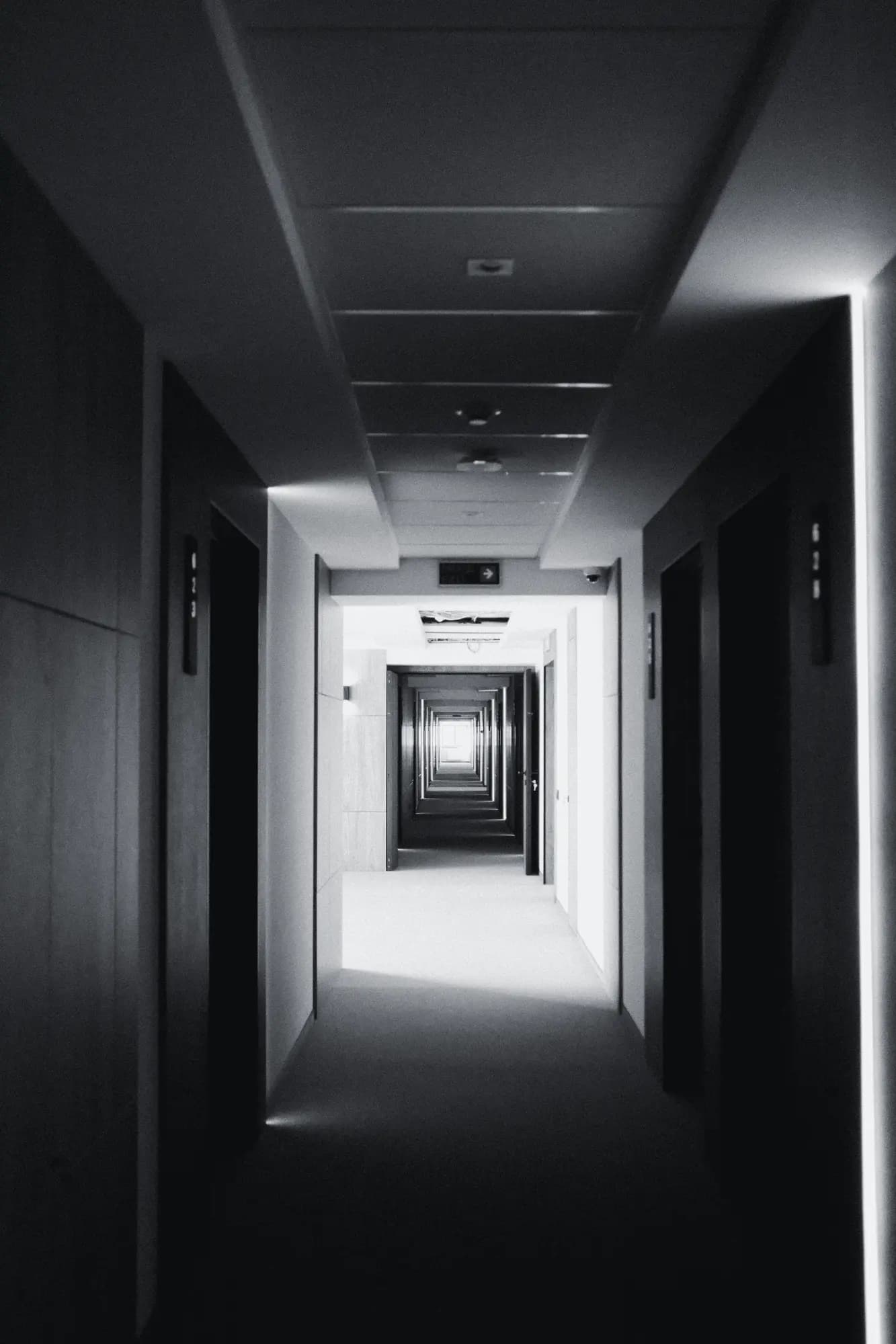 Long hotel corridor with closed room doors