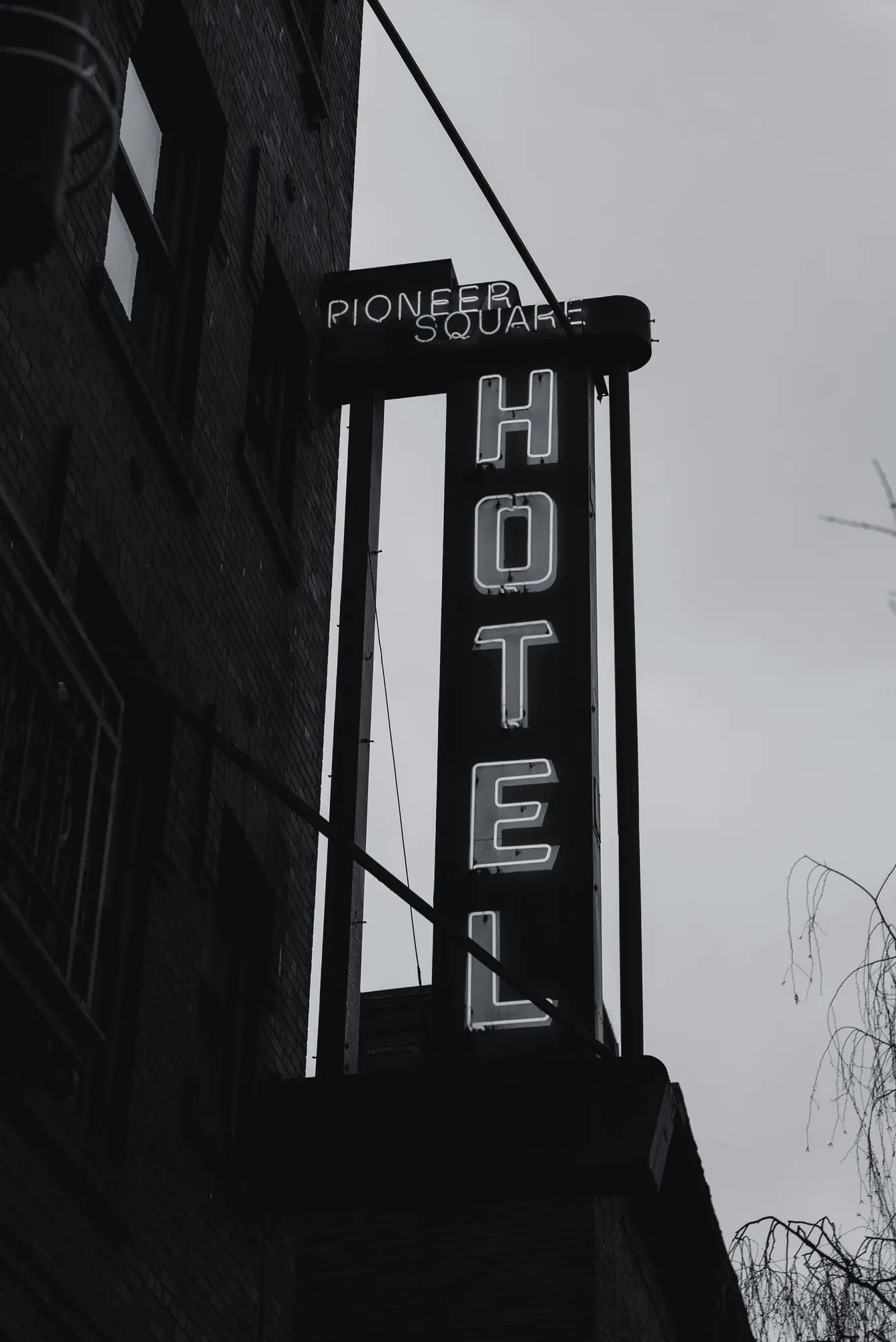Neon hotel sign on a dark brick façade