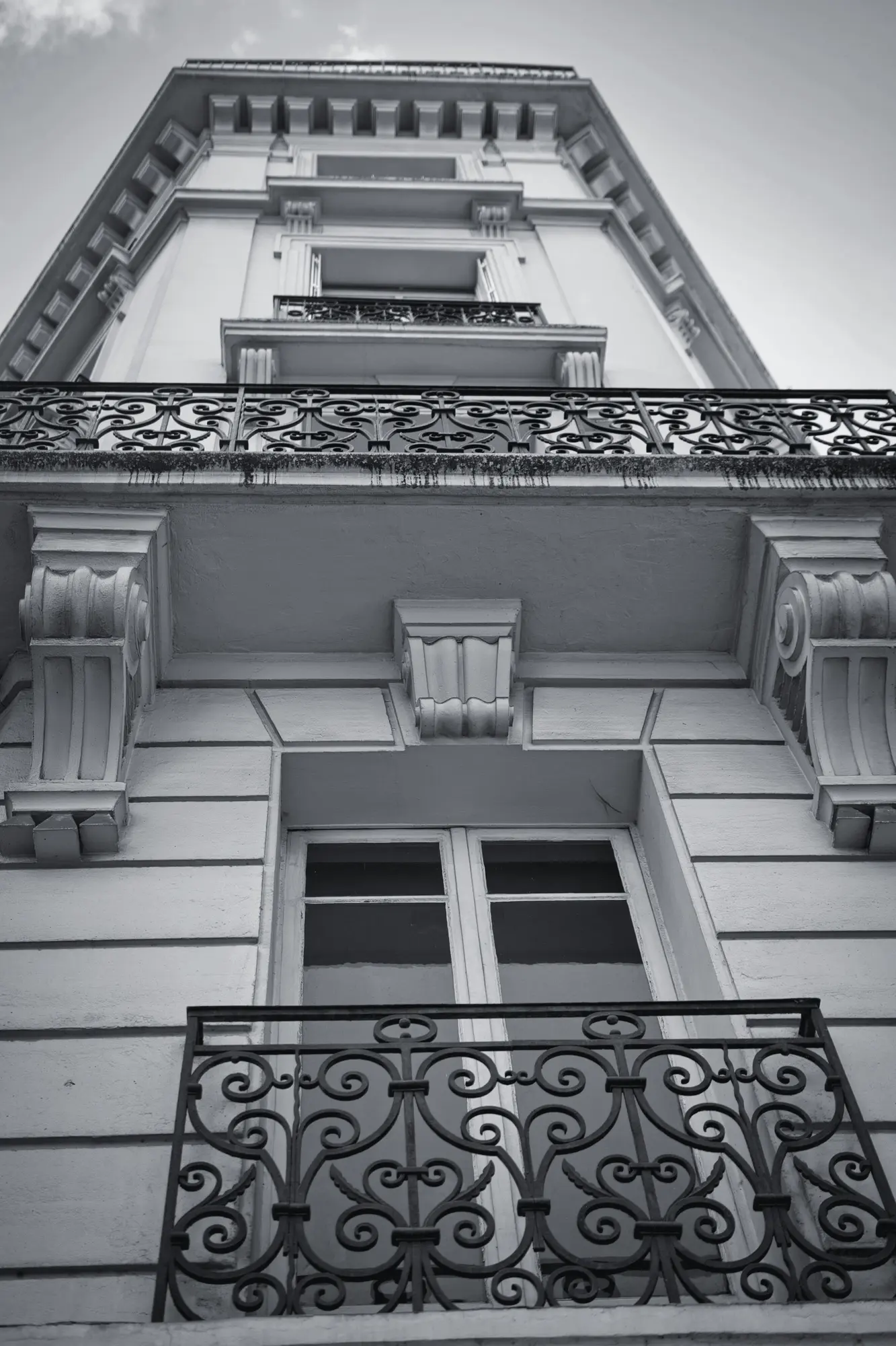 Period façade with wrought-iron balconies, seen from below